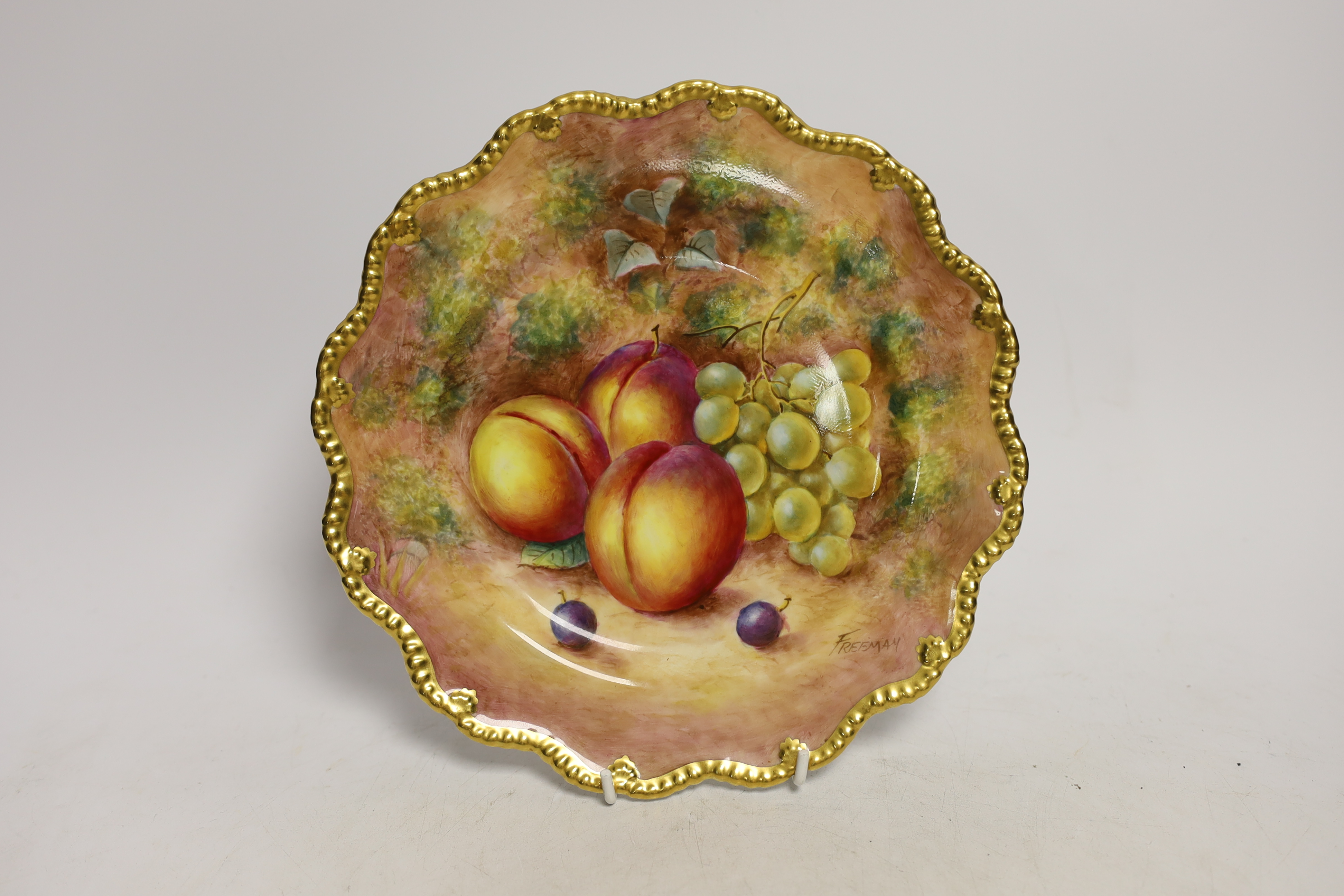 A pair of Royal Worcester fruit painted plates, post war, signed Freeman, 22.5cm